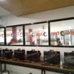 Indoor glass window signage for The One gaming cafe in Makati, featuring orange text; installed by M&G Global Ads.