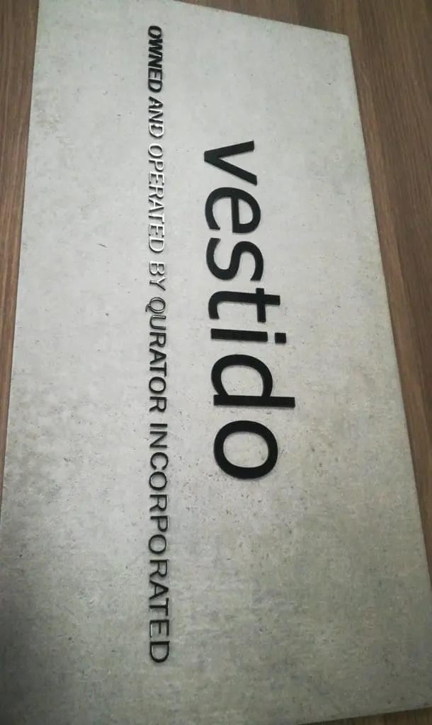 Acrylic signage for Qurator Incorporateds vestido on wood surface in Quezon City by M&G Global Ads.