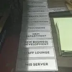 Metallic office door signage for various departments displayed on a table in Makati by M&G Global Ads.