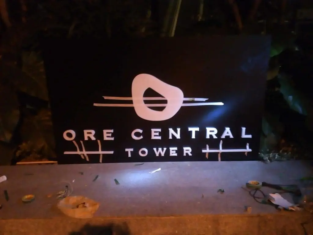 LED building signage for ORE CENTRAL TOWER in Makati, lit at night with tools nearby, by M&G Global Ads.