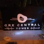 LED building signage for ORE CENTRAL TOWER in Makati, lit at night with tools nearby, by M&G Global Ads.