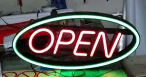 Neon acrylic OPEN signage in bright red with green oval, displayed on a table in Makati, by M&G Global Ads.
