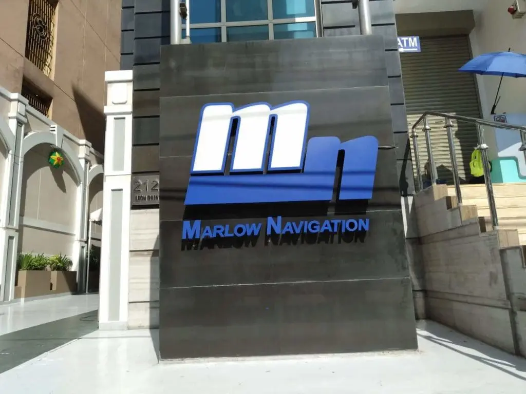 Marlow Navigation black metallic outdoor signage near building entrance in Makati, with blue and white logo, by M&G Global Ads.