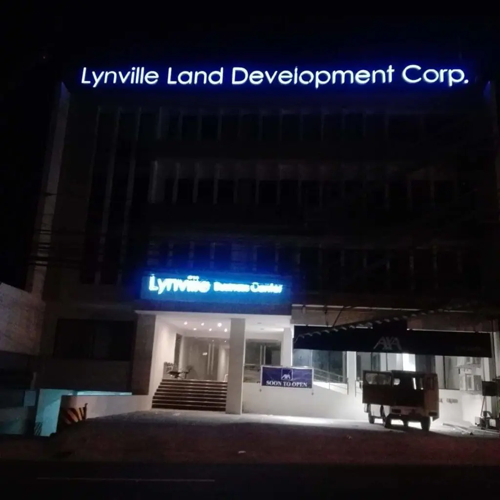 Illuminated acrylic signage for Lynville Land Development Corp in Makati, building entrance and Soon to Open banner by M&G Global Ads.
