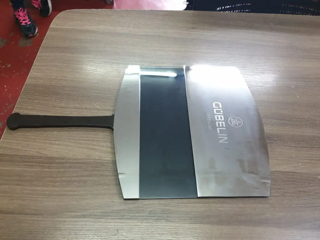 LED signage fixture and Gübelin knife on a wooden table in Makati by M&G Global Ads.