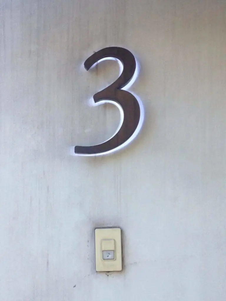 Metal 3D number signage on a light wall above a beige switch in a Makati building interior by M&G Global Ads.