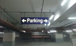 Indoor parking directional sign with Parking text and arrows, in Makati garage lighting, by M&G Global Ads.