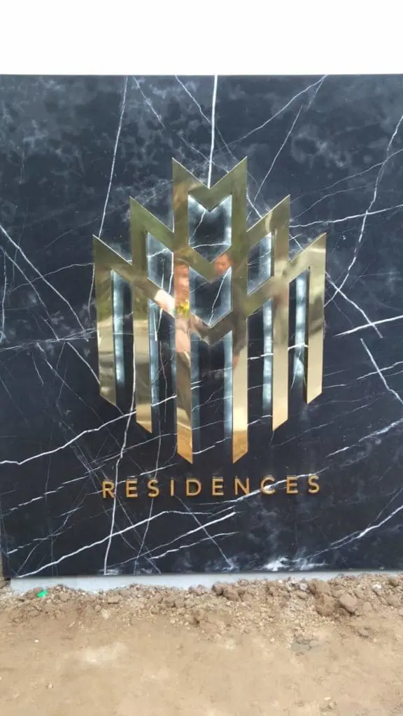 Metallic RESIDENCES signage for development in Makati with gold geometric building shapes, by M&G Global Ads.