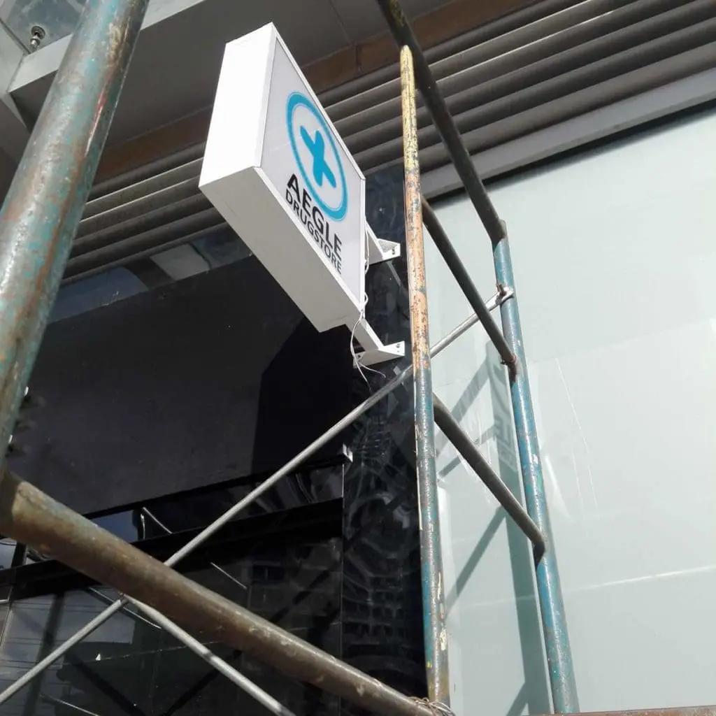 Outdoor pharmacy signage for AGILE DRUGSTORE with blue cross, Makati location, by M&G Global Ads.