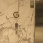 Lobby directory signage with a golden letter G above elevator buttons in Makati, by M&G Global Ads.