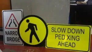 Road safety signage—narrow bridge, pedestrian crossing, SLOW DOWN PED XING AHEAD—in Makati by M&G Global Ads.