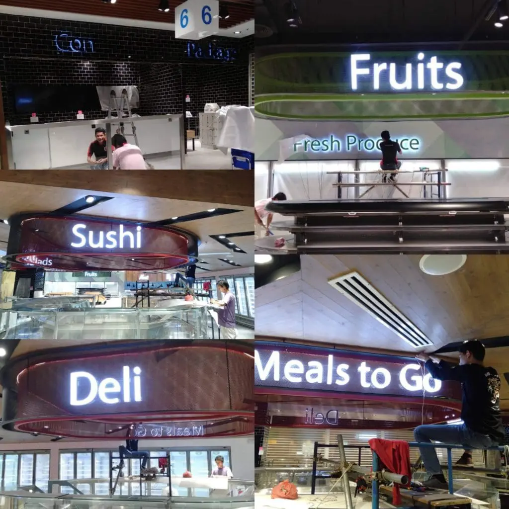 Metallic grocery signage installation—Fruits, Sushi, Deli, Meals to Go—in Quezon City supermarket by M&G Global Ads.