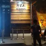 Alishan The Alley metallic storefront sign in Makati with wooden wall and barriers at night by M&G Global Ads.