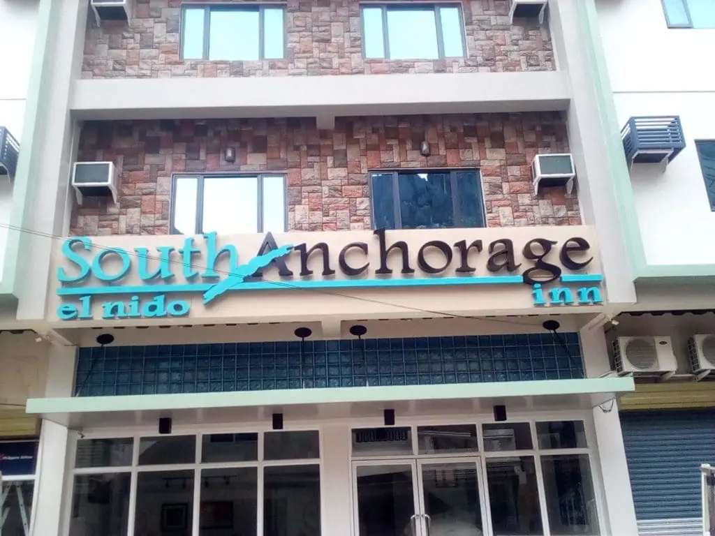 Acrylic signage for South Anchorage el nido inn on a glass and stone building in Mandaluyong by M&G Global Ads.