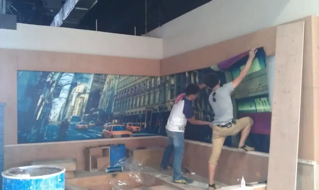 Indoor cityscape mural signage installation with yellow taxis in Makati by M&G Global Ads. Construction materials visible.