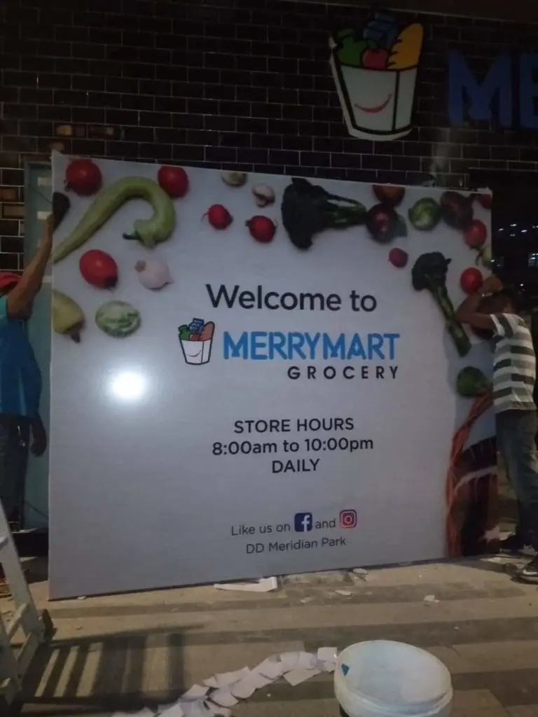 Acrylic signage for MerryMart Grocery with vegetable graphics, hours, and icons installed in Quezon City by M&G Global Ads.