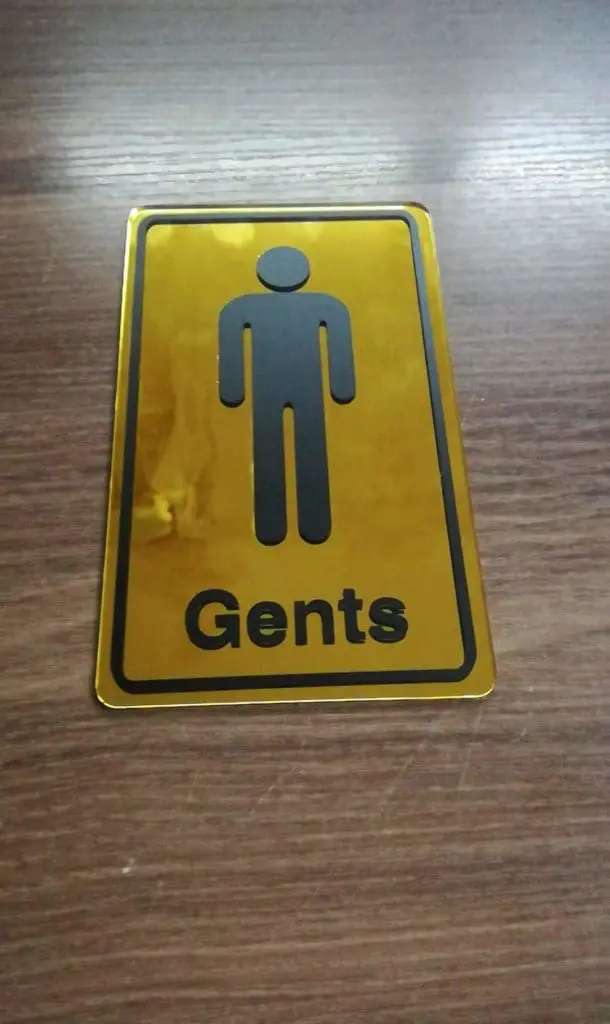Acrylic gents restroom signage in Makati with black stick figure and Gents text, gold color, by M&G Global Ads.