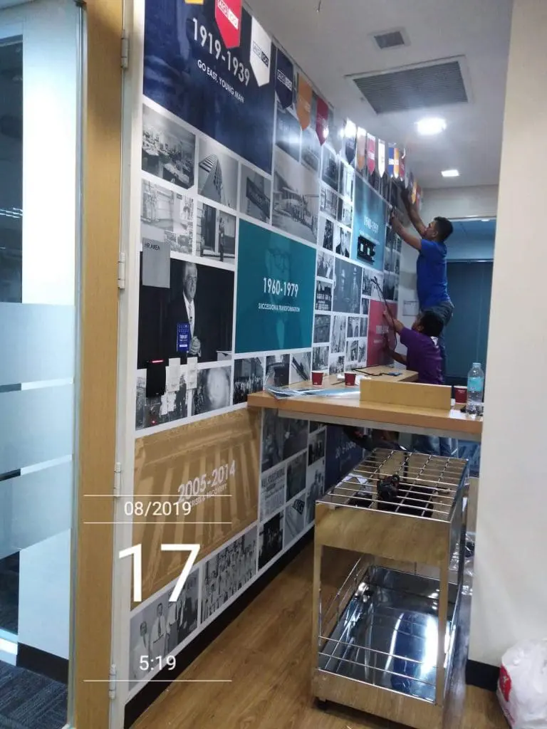 Acrylic historical timeline office signage installation in Ortigas with photos, glass door, and metal shelves by M&G Global Ads.