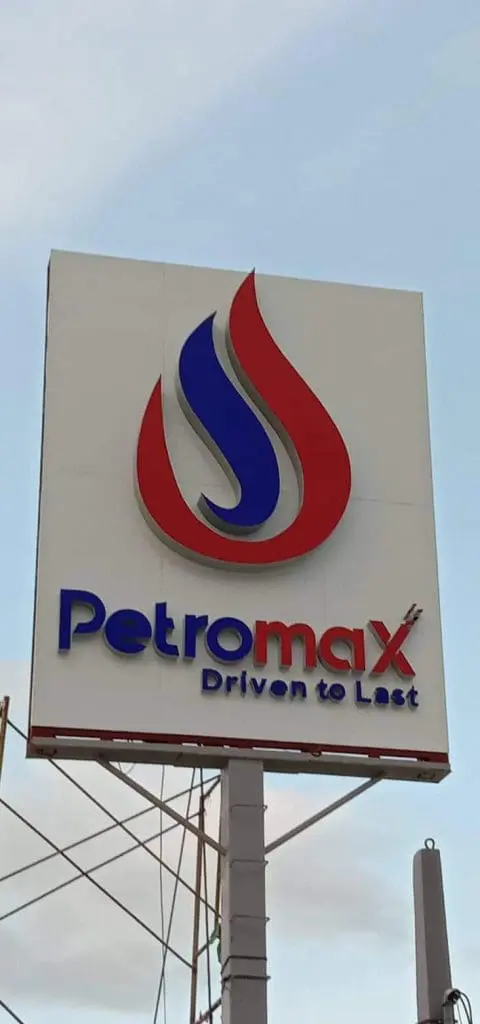 Petromax outdoor pylon signage with flame logo and slogan in Makati, mounted on tall pole under cloudy sky by M&G Global Ads.