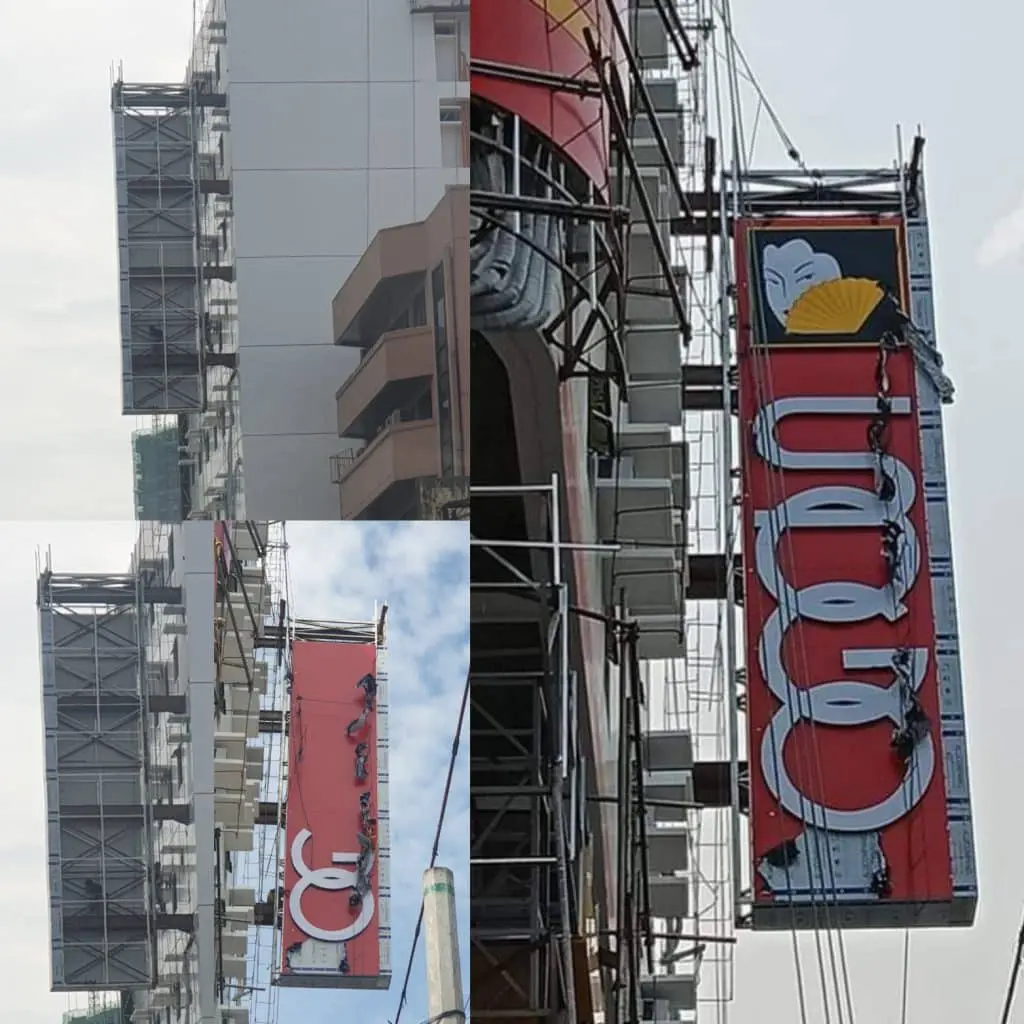 Red vertical building lighted signage with white letters and yellow fan in Ortigas, installation by M&G Global Ads.