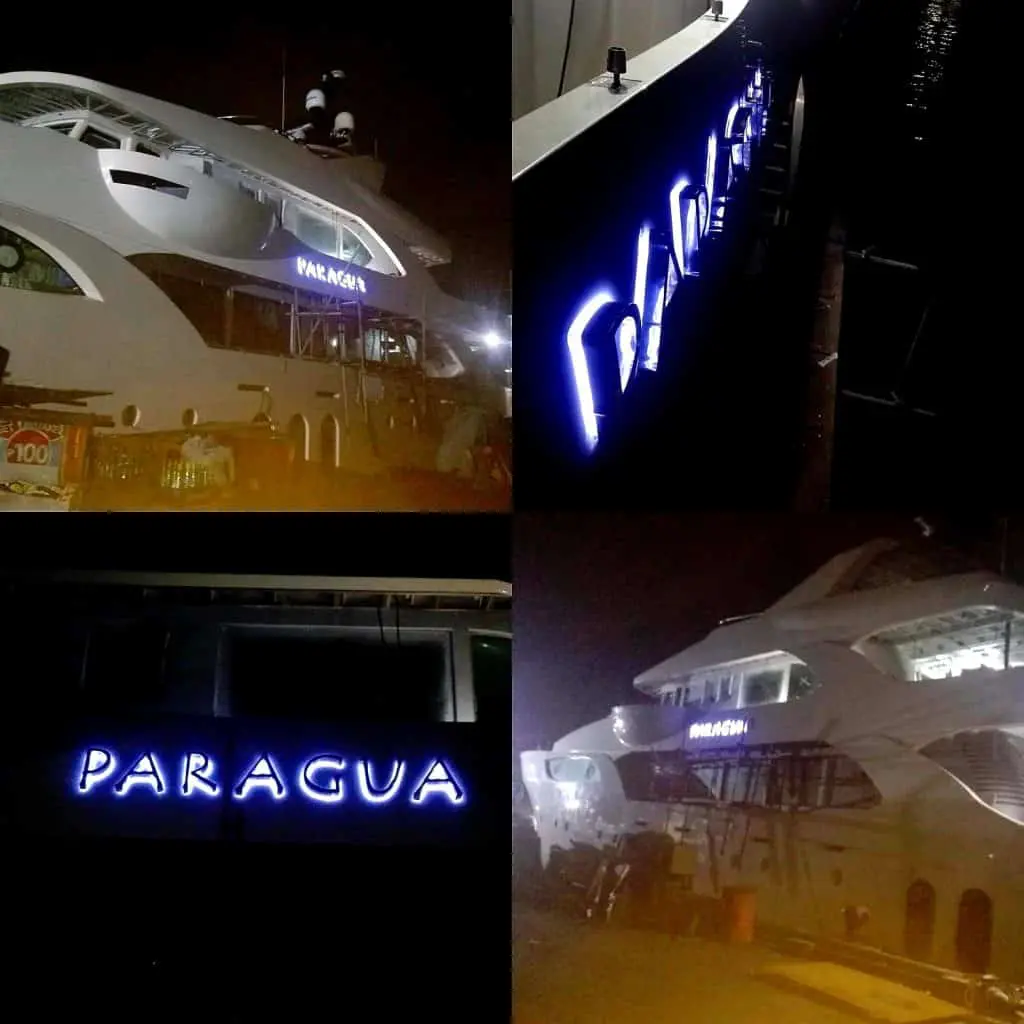 Four night photos of PARAGUA blue acrylic yacht signage, marina docked, Makati. Illuminated sign stands out. By M&G Global Ads.