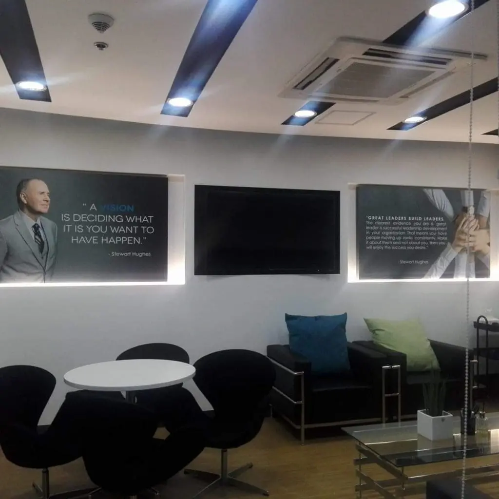 Office lounge with indoor signage for corporate client, black chairs, posters, and TV in Makati by M&G Global Ads.