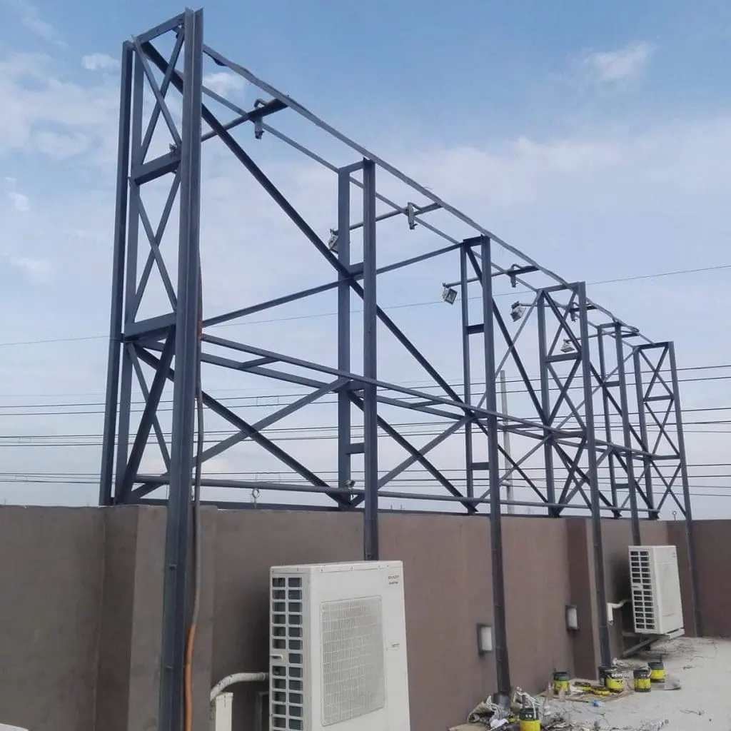 Pylon signage frame on a rooftop with A/C units below in Makati, partly cloudy sky, by M&G Global Ads.