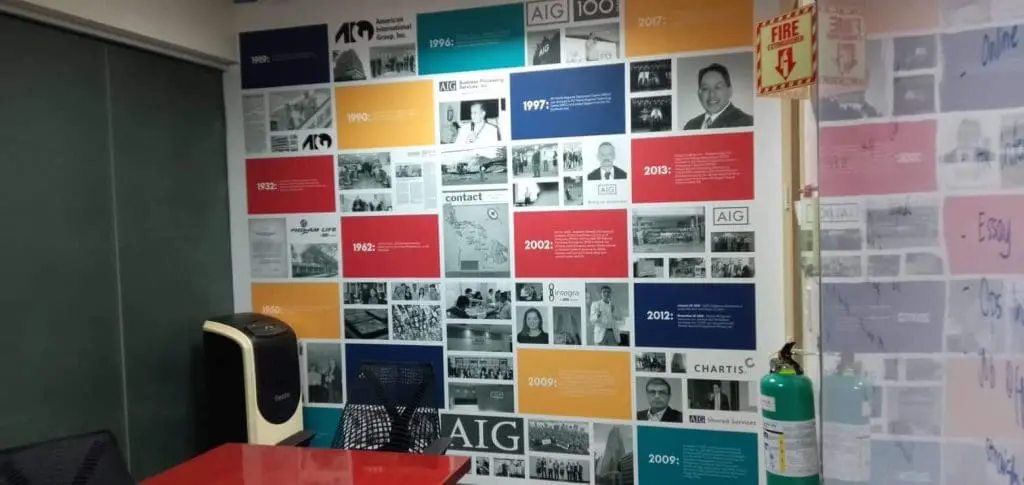 AIG timeline wall signage in an office room with a red table, black chairs, Makati location by M&G Global Ads.