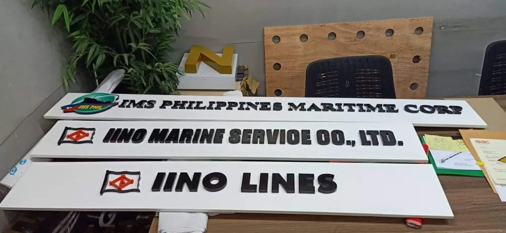 Acrylic office signboards for marine service companies in Makati, on display table with logos, by M&G Global Ads.