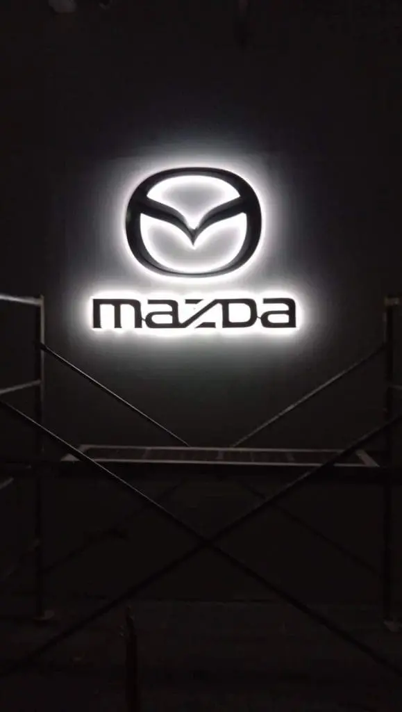 Outdoor LED signage for Mazda, featuring illuminated logo and text with scaffolding, in Quezon City by M&G Global Ads.