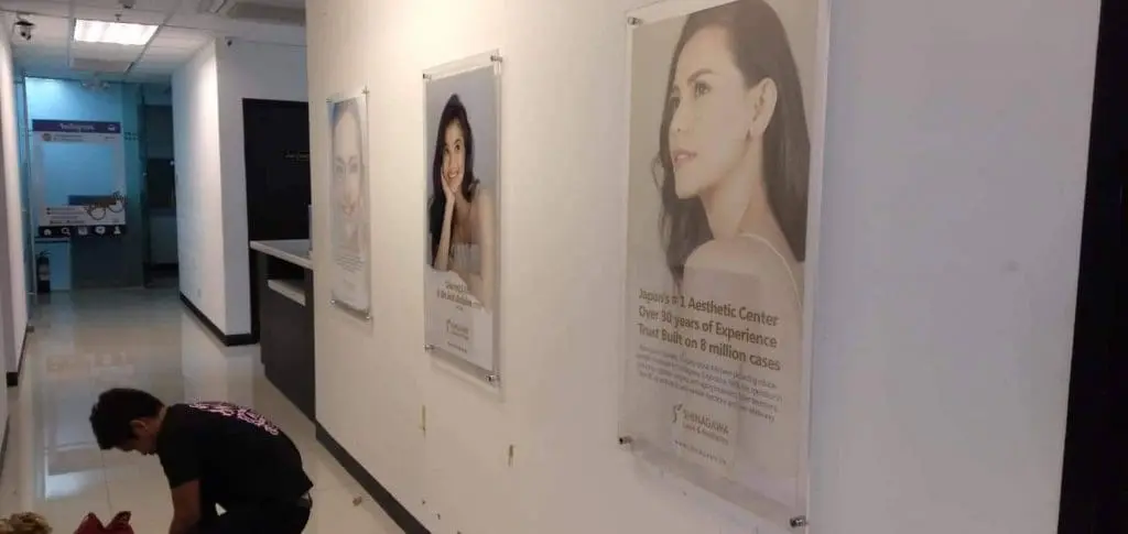 Acrylic signage and wall posters at an aesthetic clinic with patient results, Quezon City location, by M&G Global Ads.
