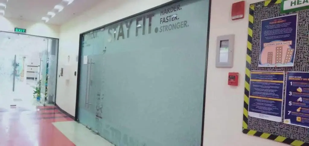 Acrylic signage and safety posters for a fitness center in Makati, red and white floor, glass doors—by M&G Global Ads.