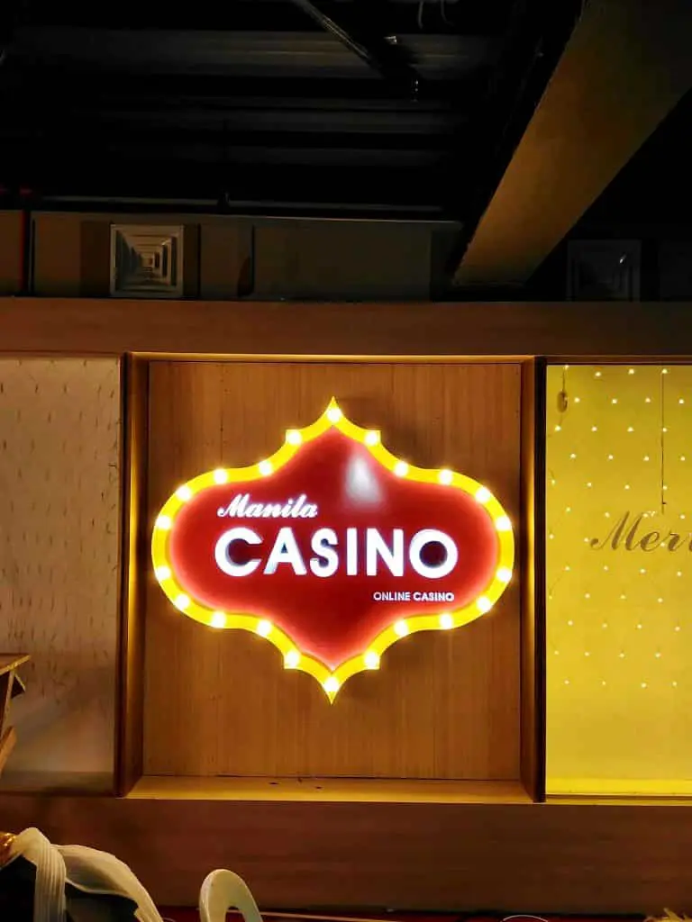 Manila Casino LED building signage, wood backdrop, Quezon City location, bright yellow border lights, by M&G Global Ads.
