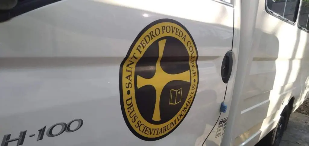 Saint Pedro Poveda College logo vehicle wrap and Latin building signage in Ortigas, Metro Manila by M&G Global Ads.