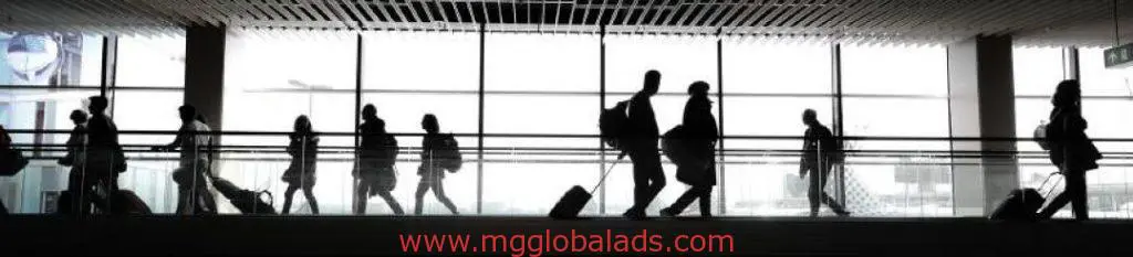 Travelers with luggage walk past airport wayfinding signage in a bright terminal in Pasig by M&G Global Ads.