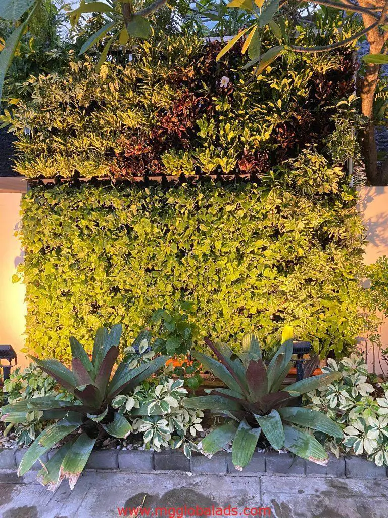 Vertical garden with metallic signage, green and red plants, stone border in Mandaluyong, by M&G Global Ads.