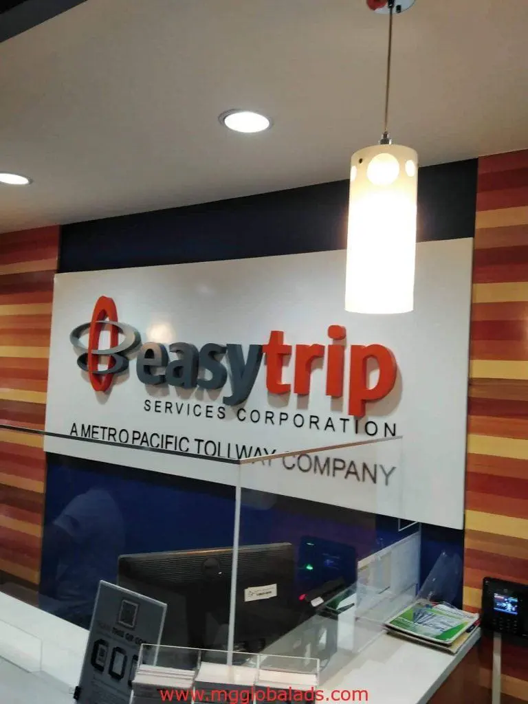 Acrylic signage for Easytrip Services Corporation in a Makati reception area, logo and tagline on wood wall by M&G Global Ads.