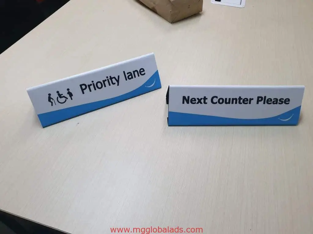 Metallic Priority Lane desk sign with accessibility icons and acrylic Next Counter Please sign for Makati offices by M&G Global Ads.