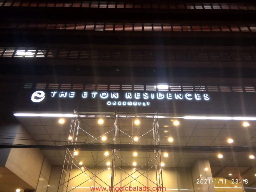 Eton Residences Makati entrance with bright LED signage by M&G Global Ads, scaffolding and ceiling lights, night view.