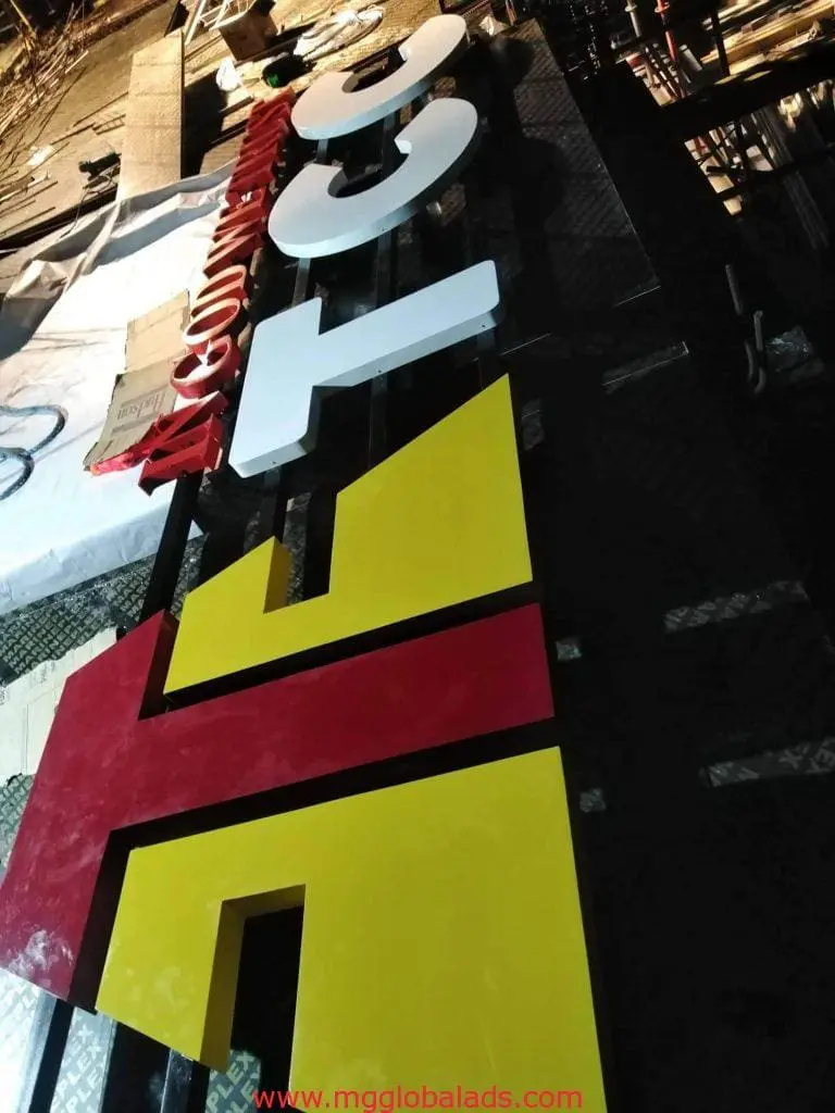 3D building signage with bold yellow, red, and white letters being assembled in Mandaluyong workshop by M&G Global Ads.