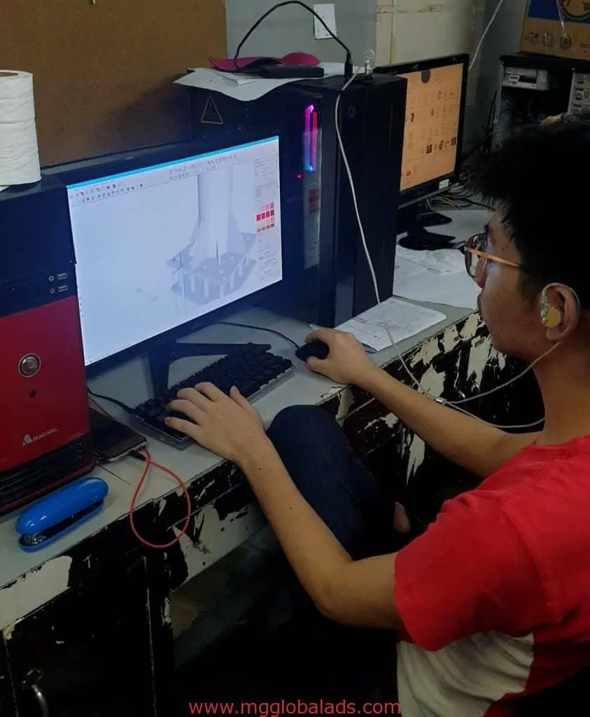 Designer creating a 3D model of building signage for a client in Makati, workspace view, by M&G Global Ads.