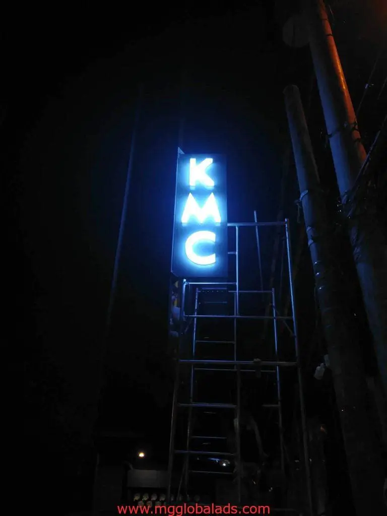LED pylon signage for KMC in Makati: tall metallic structure with blue letters, night-lit. Installed by M&G Global Ads.