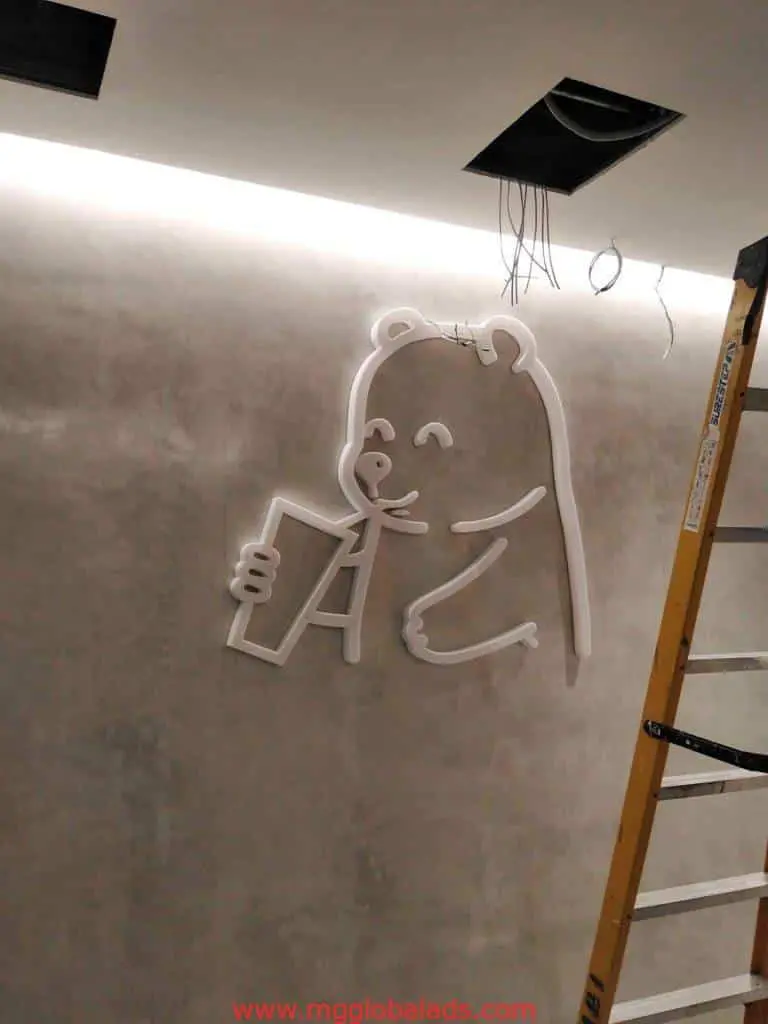 Custom neon signage of a bear with drink on gray wall with yellow ladder, Ortigas location, by M&G Global Ads.