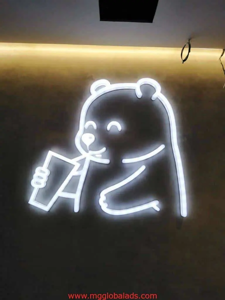 White LED neon signage of a cartoon bear drinking from a cup with straw, Ortigas location, by M&G Global Ads.