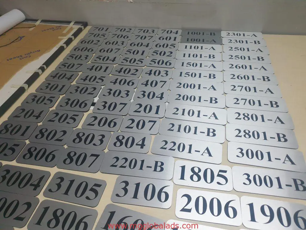 Rectangular metallic building signage with black text and codes like 701, 2301-A in Makati by M&G Global Ads.