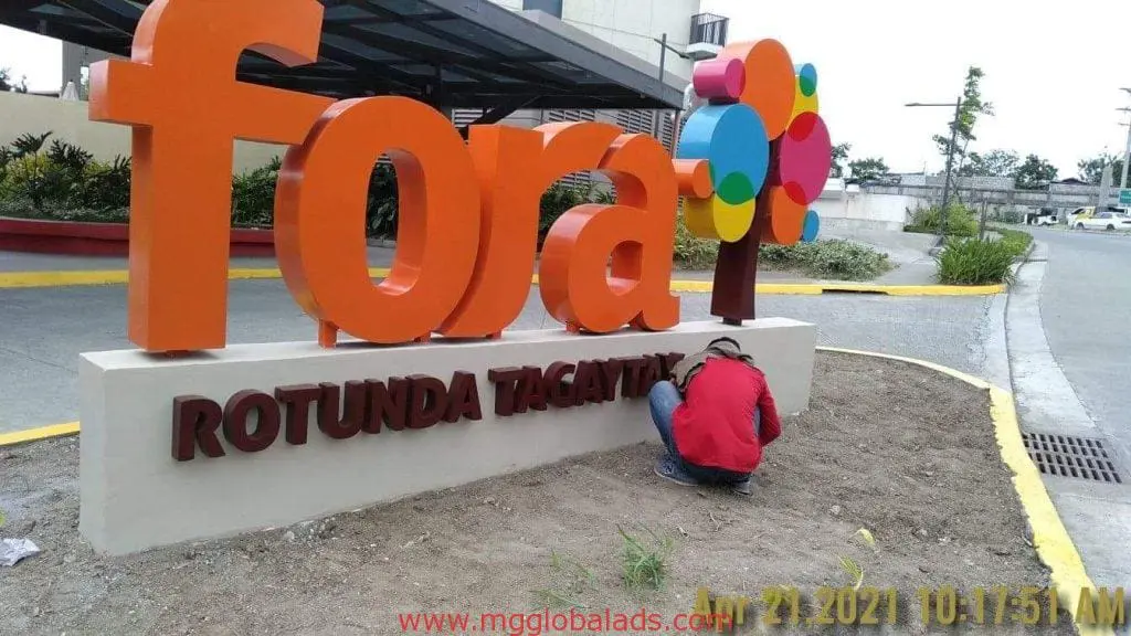 Fora Rotunda Tagaytay pylon signage for Fora, with worker landscaping, Ortigas location, by M&G Global Ads.