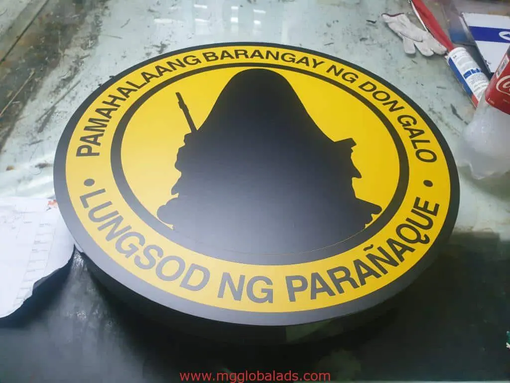 Round outdoor barangay signage for Don Galo, Parañaque in Makati with yellow background and black border by M&G Global Ads.