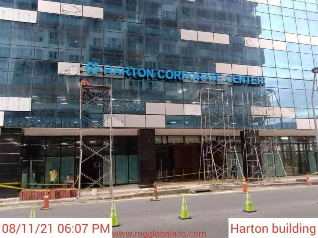 Acrylic signage for Harton Corporate Center, glass-fronted facade under construction in Mandaluyong by M&G Global Ads.