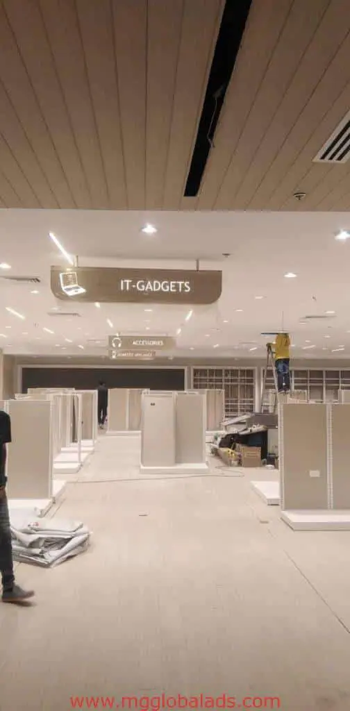 Metallic IT-GADGETS signage for retail store in Mandaluyong under construction, shelves empty, by M&G Global Ads.