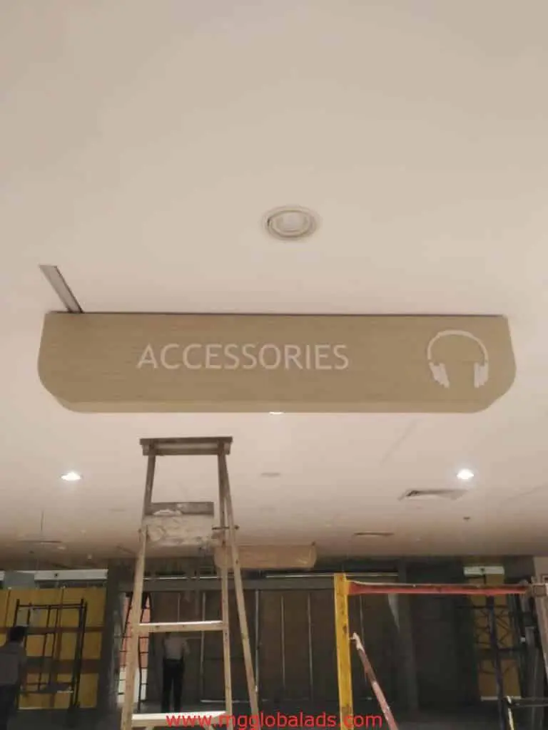 Wooden accessories store signage with headphone icon, ceiling-mounted in Makati, under construction. By M&G Global Ads.